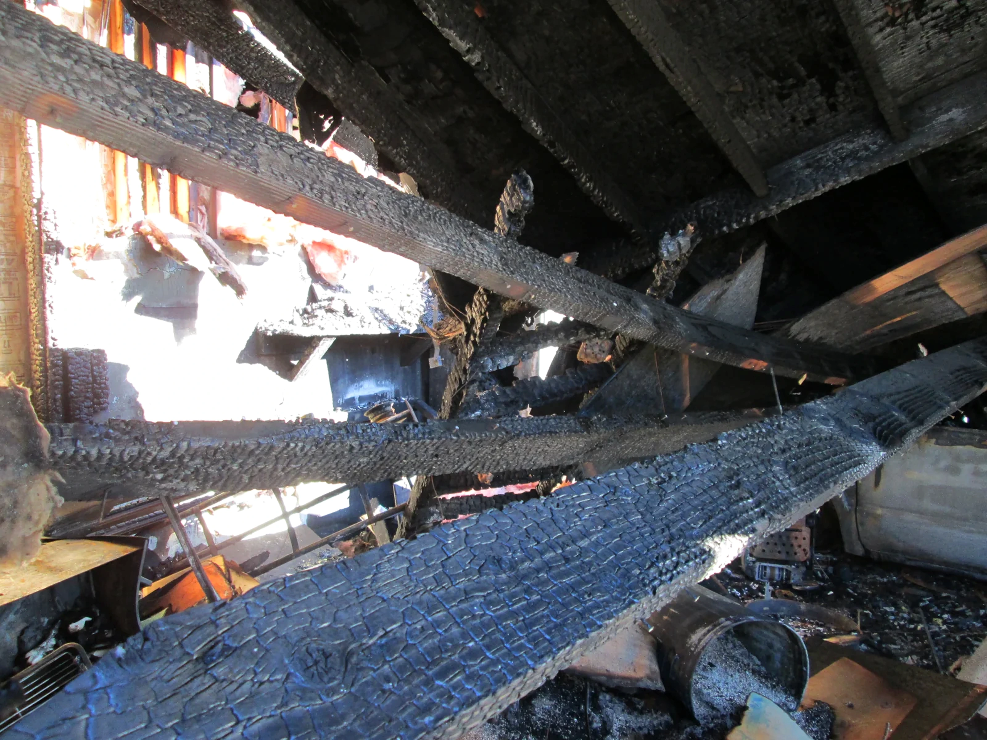 Charred roof beams and debris after a property fire