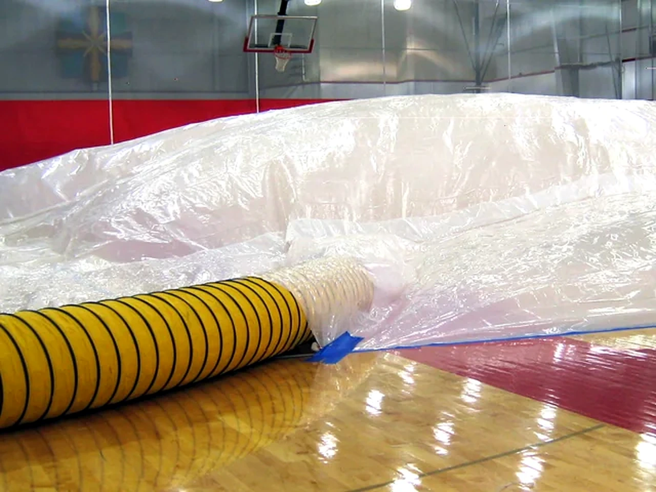 Drying equipment and containment sheeting on a gymnasium floor