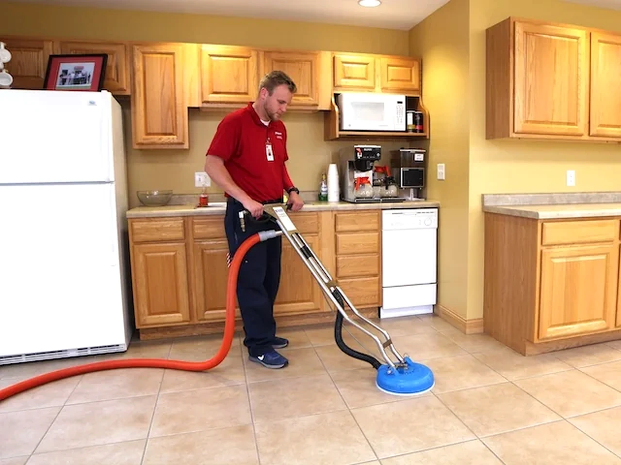 Peerless technician cleaning a kitchen tile floor